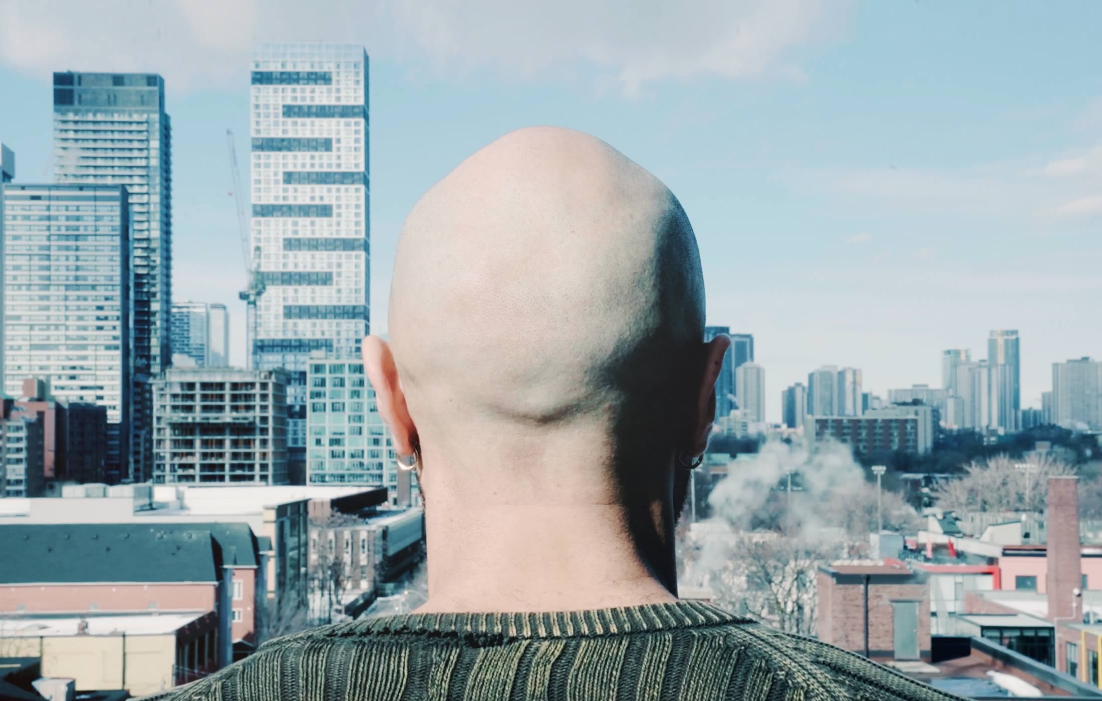 Photograph of a black man surveying the Toronto skyline, sourced from the Untold Toronto microsite