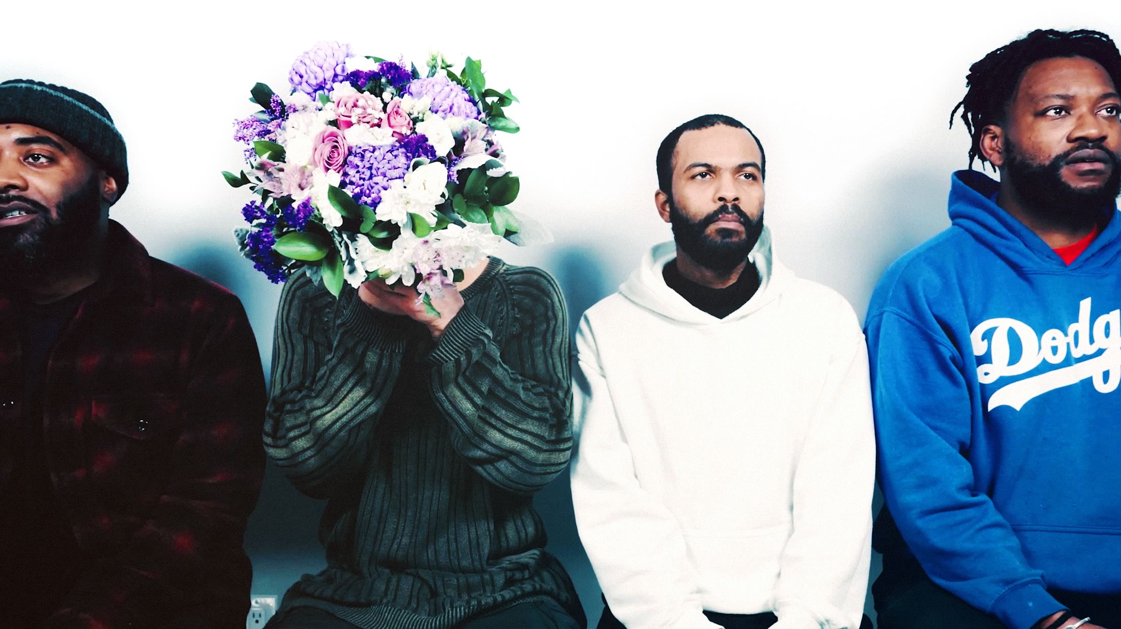 Photograph of four black men sitting in a row (as sourced from the Untold Toronto microsite)